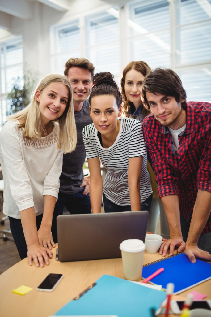 Group of business executives smiling at camera at their desk